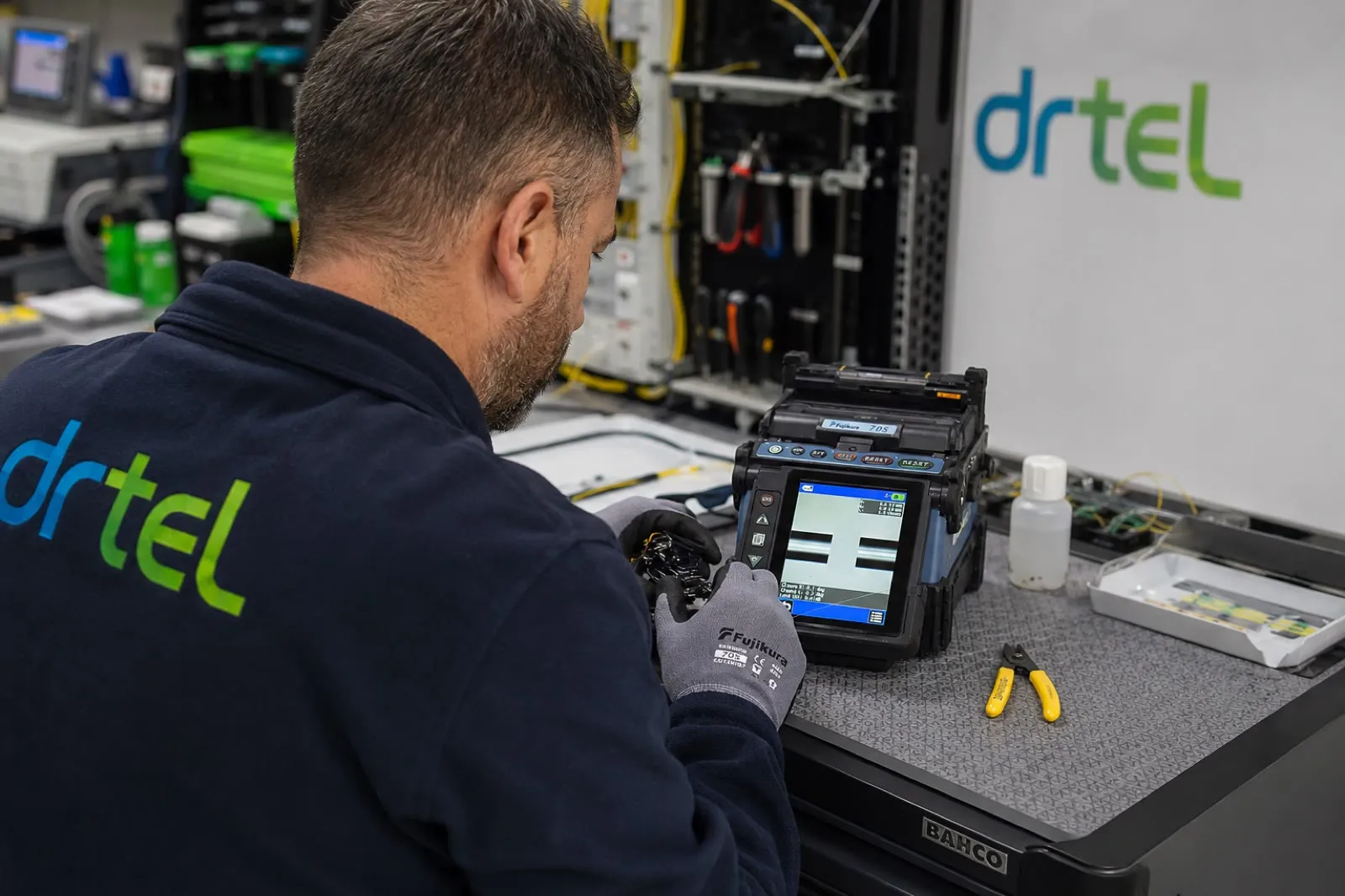 Técnico de DRTEL fusionando fibra óptica en el taller